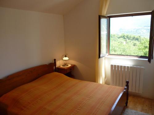 een slaapkamer met een bed en een groot raam bij Apartment Panorama in Klis