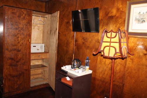 Habitación con TV en una pared de madera. en The Oakwood Hotel en Nairobi