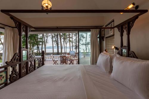 sypialnia z łóżkiem i widokiem na ocean w obiekcie Casa Del Mer by StayVista - Nearby beach with, sea-view rooms & coconut farm w mieście Alibag