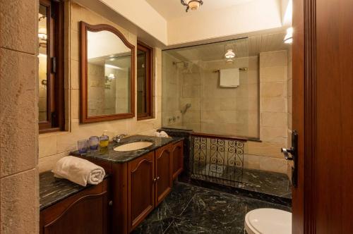 W łazience znajduje się umywalka i lustro. w obiekcie Casa Del Mer by StayVista - Nearby beach with, sea-view rooms & coconut farm w mieście Alibag
