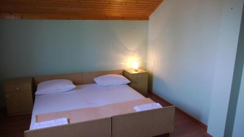a small bedroom with a bed with a light on it at Rooms & Apartments Blue Beach in Vodice