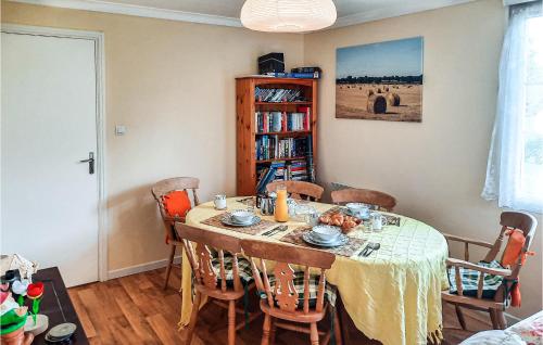 a dining room table with chairs and a book shelf at 2 Bedroom Awesome Home In Chelun in Chelun