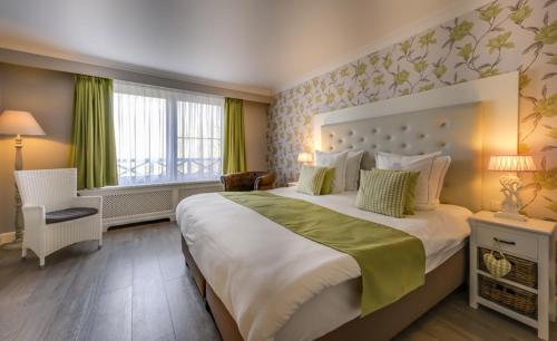 ein Hotelzimmer mit einem großen Bett und einem Fenster in der Unterkunft Ara Dune Hotel in De Panne