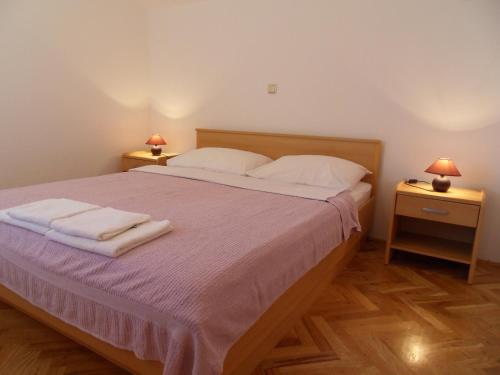 a bedroom with a large bed with two night stands at Apartments Petricevic 2 in Selce