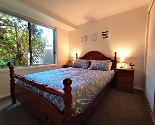 a bedroom with a bed with a large window at Clearwaters Albury in Albury