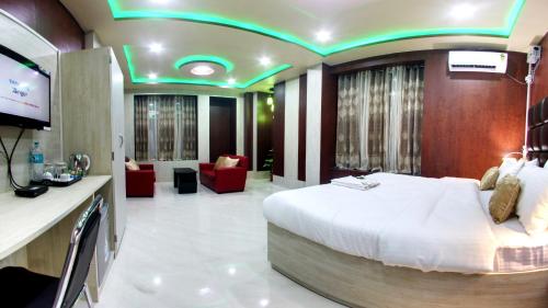um quarto de hotel com uma cama e uma televisão em wings THE PRIDE em Jorhāt