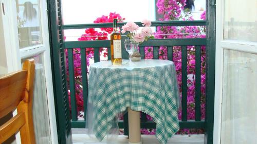 a bottle of wine on a table on a balcony at Syrianos Hotel in Naxos Chora