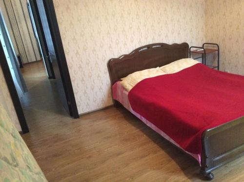 a bedroom with a bed with a red blanket at Studio Lermontov Street in Tbilisi City