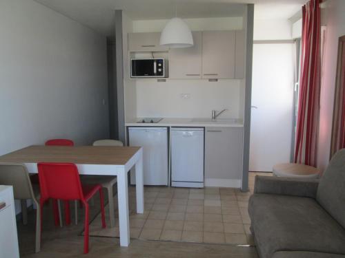 a kitchen and living room with a table and chairs at Résidence Mer & Golf Sokoburu in Hendaye