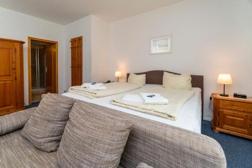 a bedroom with a bed with two towels on it at Hotel Holsteinische Schweiz am Dieksee in Malente
