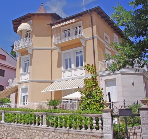 a large yellow building with a balcony at Guest House Villa Dagmar in Crikvenica