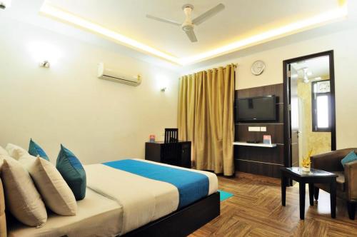 une chambre d'hôtel avec un lit et une télévision dans l'établissement RR Residency, à New Delhi