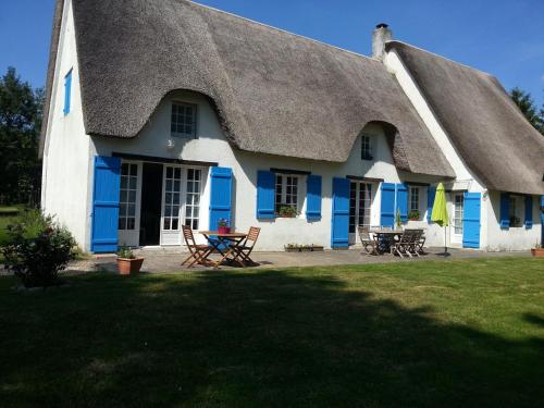 Casa azul y blanca con techo de paja en Les Nymphéas, en Saint-Lyphard