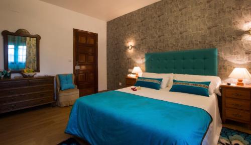 a bedroom with a large bed with a blue headboard at Hotel & Apartamentos Cons da Garda in San Vicente de O Grove