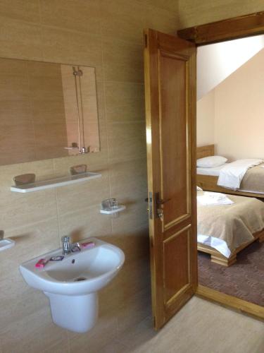 a bathroom with a sink and a bed at Hotel Adial in Adjud