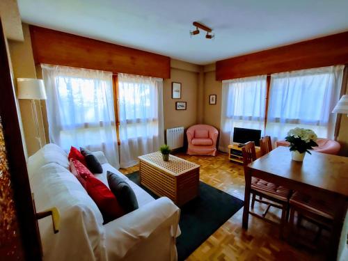 sala de estar con sofá blanco y mesa en Apartamento Puerto de Navacerrada, en Cercedilla