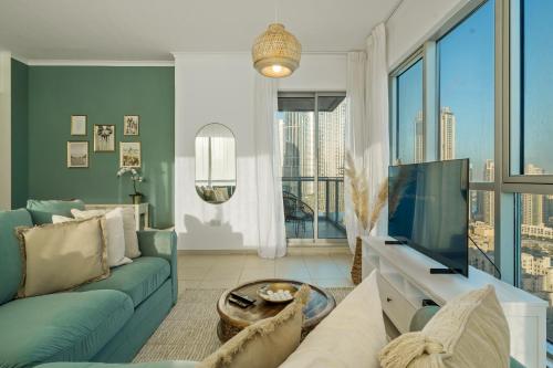 uma sala de estar com um sofá azul e uma televisão em Chic and Zen Apartment, Near Burj Khalifa Tower em Dubai