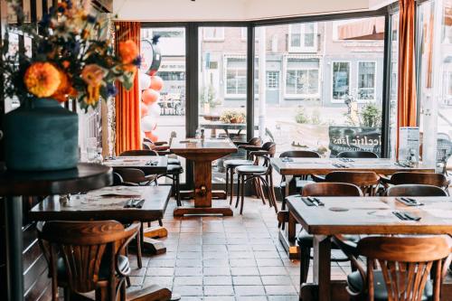 un restaurante con mesas y sillas y una ventana en Hotel Café Restaurant Abina, en Amstelveen