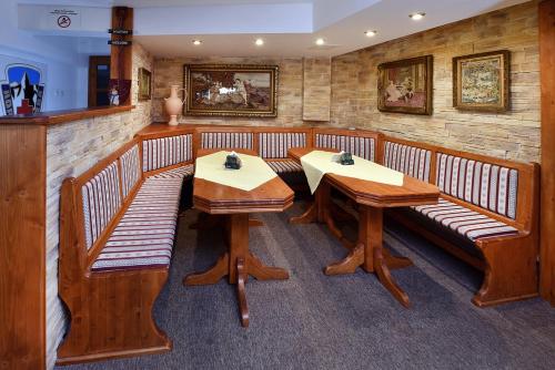 a dining room with benches and tables in it at Wellness Vila Astra in Stará Lesná