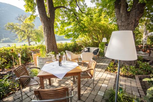 a table and chairs on a patio with a lamp at Donauwirt - Hotel garni in Weissenkirchen in der Wachau