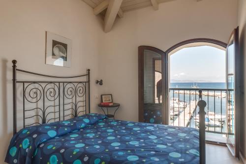 a bedroom with a bed and a view of the ocean at La Vecchia Scuola in Cavo