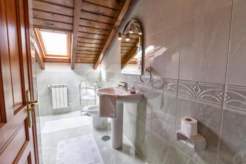 a bathroom with a sink and a toilet and a mirror at Casa Vacacional Miyares in La Estrada