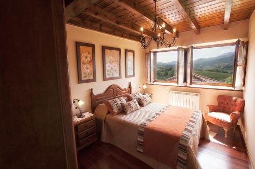 1 dormitorio con cama, ventana y silla en Casa Vacacional Miyares, en La Estrada