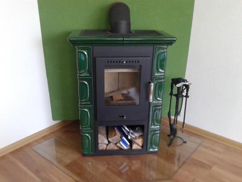 a green fireplace in a corner of a room at Apartmán Liptov in Lúčky