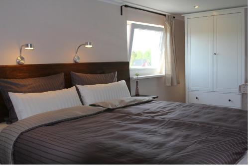 a bedroom with a large bed and a window at Ferienwohnungen In den Wiesen Oranienburg in Oranienburg