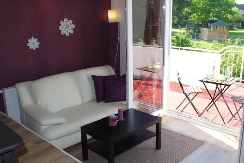 a living room with a white couch and a table at Ferienwohnungen In den Wiesen Oranienburg in Oranienburg