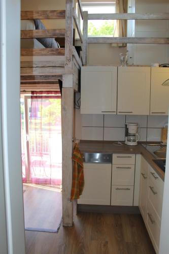 a kitchen with white cabinets and a counter top at Ferienwohnungen In den Wiesen Oranienburg in Oranienburg