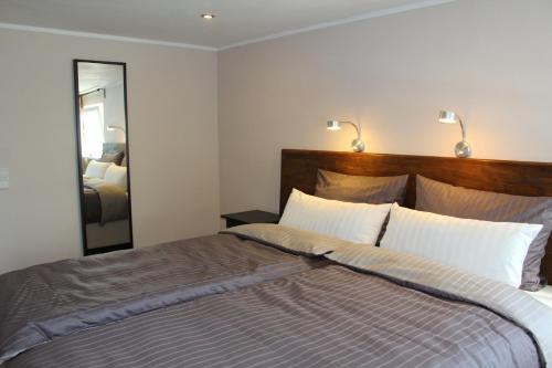 a bedroom with a large bed with a large mirror at Ferienwohnungen In den Wiesen Oranienburg in Oranienburg