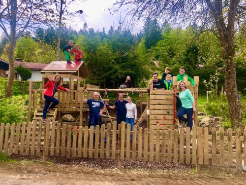 a group of people standing behind a wooden fence at Maier Pension in Bayerisch Eisenstein