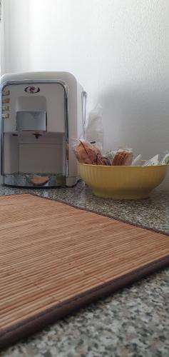 un tazón de pan junto a una tostadora en una barra en RoomsCarli en Comacchio
