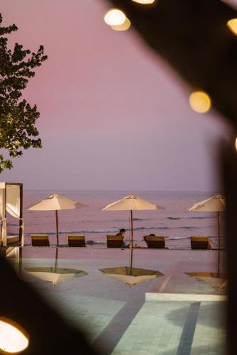 a view of a beach with umbrellas and the ocean at VAYNA Boutique Koh Chang in Ko Chang
