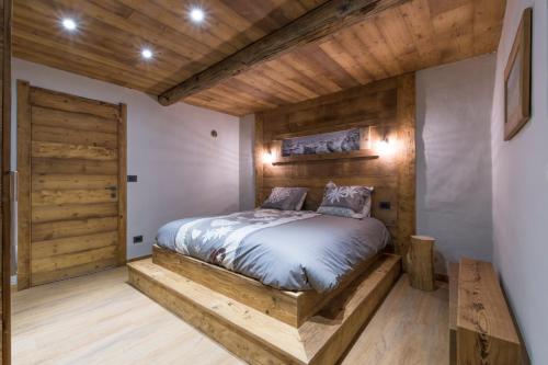 een slaapkamer met een bed en een houten deur bij Casaborgovecchio Abete Rosso-Sauna in Bardonecchia