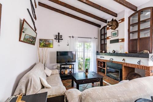 a living room with a couch and a fireplace at Tu Villa Rural Almendro 3 Dormitorios in Alhaurín el Grande