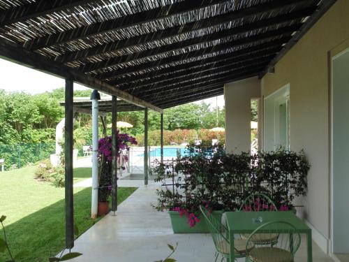 a patio with a wooden pergola and a pool at Agriturismo Dell'Orto Apartments in Verona