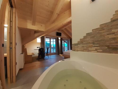 a bath tub in a room with a stone wall at B&B Fontanella in San Lorenzo in Banale