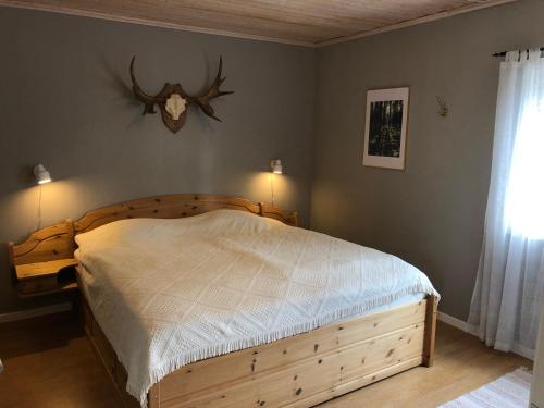 a bedroom with a bed with a wooden bed frame at Gården Ekön in Forserum