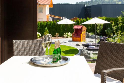 a table with two glasses and wine bottles on it at Hotel Bergidyll in Pfronten