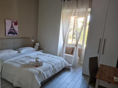 a white bedroom with a bed and a window at ESPOSITO PLAZA- ROOMS & SUITE in Naples