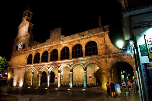 a large building with people standing outside at night at Hostal Nuevo Milán I in San Clemente