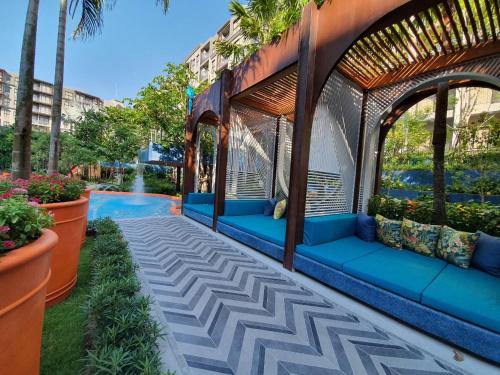 una pérgola con sofás azules junto a una piscina en Lahabana Huahin by Moji, en Hua Hin