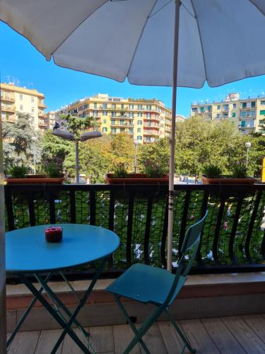 een blauwe tafel en stoel op een balkon met een parasol bij ESPOSITO PLAZA- ROOMS & SUITE in Napels