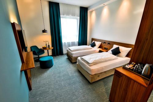 Hotel Das Zeit في Lenzing: غرفة فندقية بسريرين ومكتب