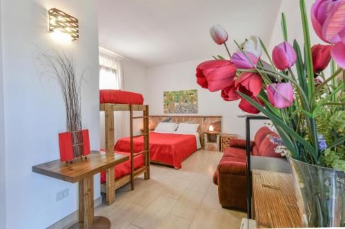 a living room with a bed and flowers in a room at Calasole Country House in Torre Lapillo