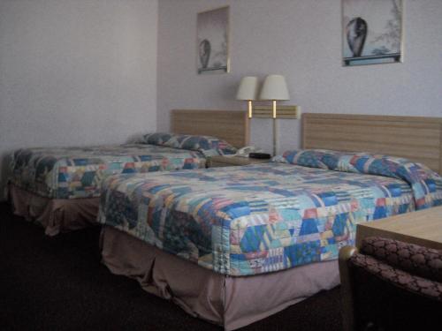 ウェストミンスターにあるPalms Courtyard Innのベッド2台とテーブルが備わるホテルルームです。