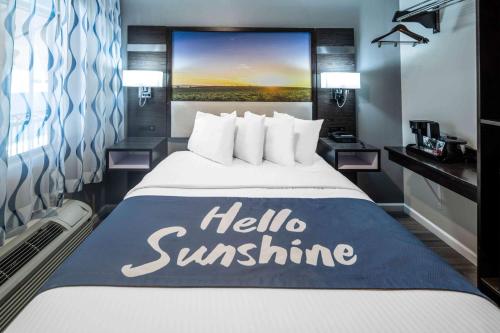 a hotel room with a bed with a hello sunshine sign on it at Days Inn by Wyndham Galt - Elk Grove South in Galt