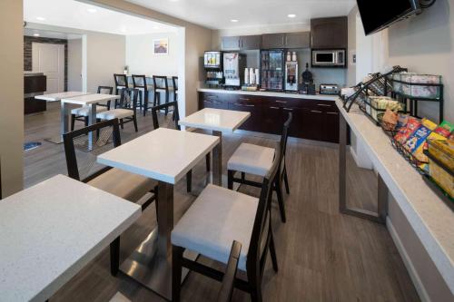 a restaurant with tables and chairs and a kitchen at Days Inn by Wyndham Galt - Elk Grove South in Galt